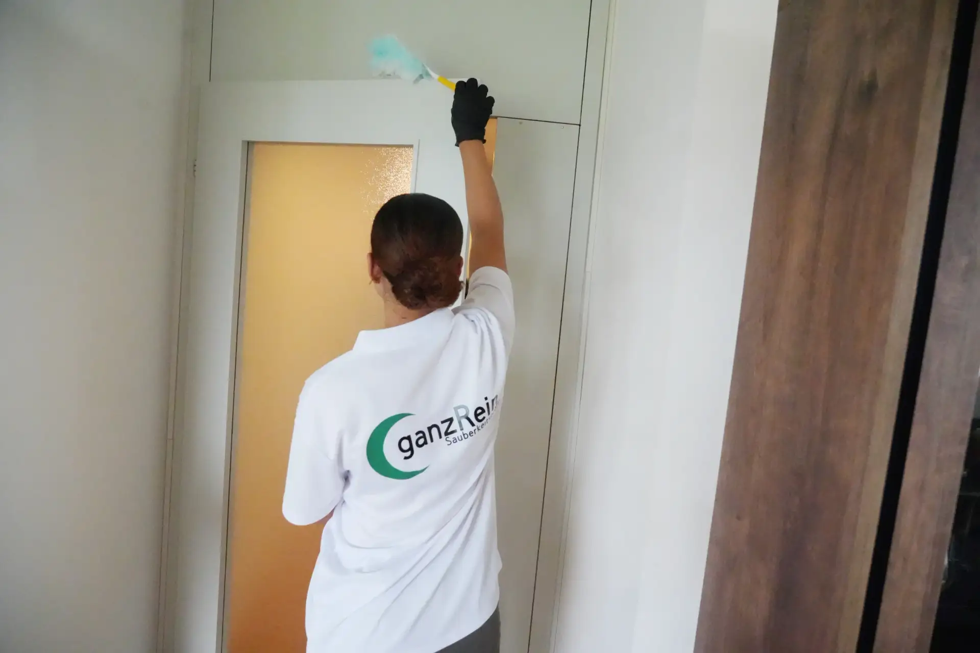 Reinigungskraft wischt gründlich Böden während einer Frühjahrsreinigung in einem Wohnzimmer