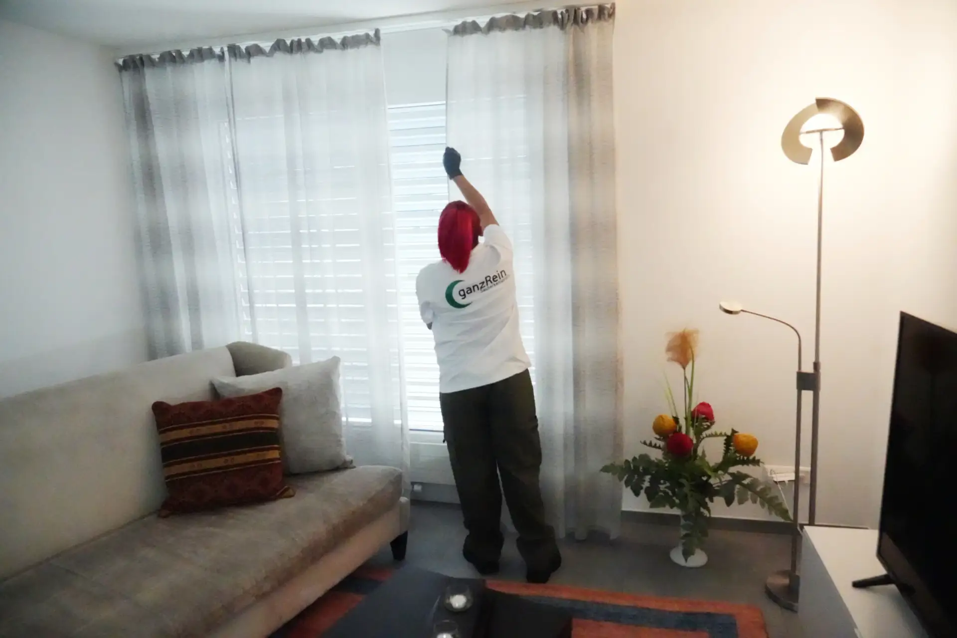 Reinigungskraft wischt den Boden in einer hellen, modernen Wohnung