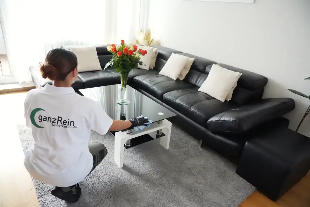 Reinigungskraft säubert ein Badezimmer sorgsam mit modernen Putzmitteln